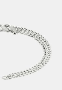 Bracciale in metallo argento con design intrecciati, caratterizzato da una superficie liscia e lucida e un motivo a spina di pesce lungo tutta la sua lunghezza.