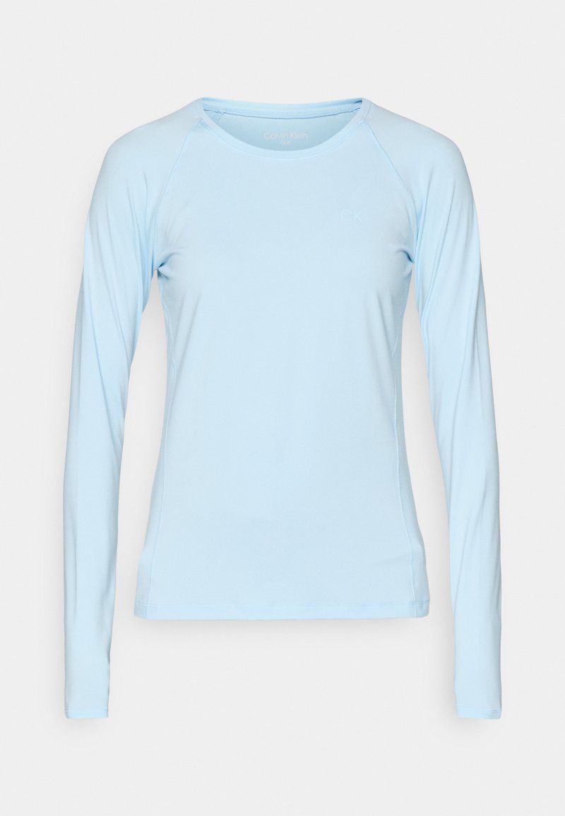 Jasnoniebieska koszula z długim rękawem z okrągłym dekoltem. Wykonana z gładkiego, elastycznego materiału. Posiada rękawy raglanowe oraz minimalne logo na piersi.