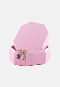 Rosa oktagonal smykkeskrin med strukturert overflate, som inneholder et par gullbelagte dråpeøreringer med lilla edelstener.