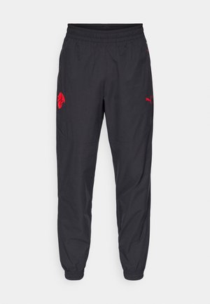 Zwarte sportbroeken met een elastische tailleband, nauwsluitende boorden en rode logo-accenten. Beschikt over lichtgewicht, gladde stof en een taps toelopend ontwerp.