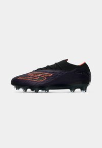 Black synthetic soccer cleat with textured surface, orange accents, rounded toe, and multi-studded sole for traction on grass.