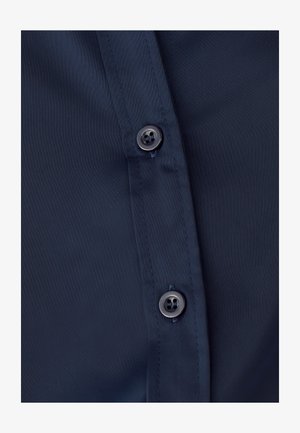 Granatowa koszula z gładkiego materiału, z dwoma ciemnymi guzikami wzdłuż listwy, prezentująca klasyczny design z guzikami.