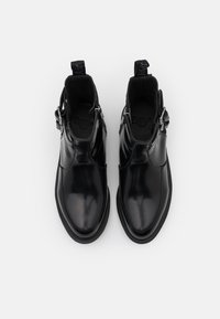 Botas de tobillo de cuero negro con un acabado suave, que cuentan con un cierre lateral de cremallera, lengüetas para el talón y una suela texturizada para mayor agarre.
