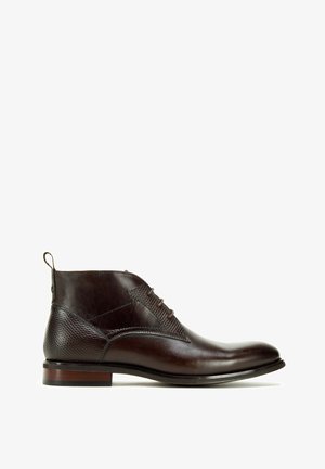 Hnědé kožené kotníkové boty s texturovanou boční panely, složitým šněrováním a kontrastní podešví s dřevěným akcentem.