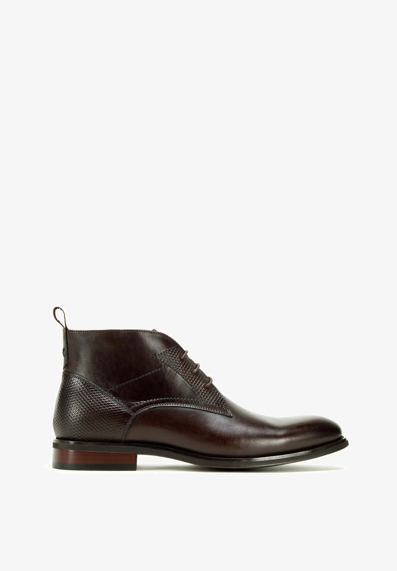 Hnědé kožené kotníkové boty s texturovanou boční panely, složitým šněrováním a kontrastní podešví s dřevěným akcentem.