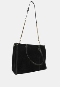 Bolso de lona negro de ante con asas de cuero y herrajes en tono dorado, que presenta un diseño espacioso y un bolsillo frontal.