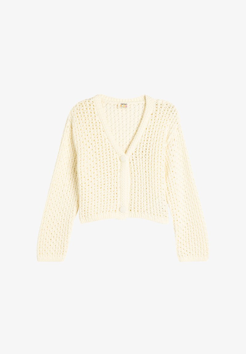 Crochet neulepusero pehmeässä kerma-värissä, jossa on V-kaula-aukko, pitkät hihat ja kaksi etupainiketta. Koko neulepinnassa on teksturoitu avonainen neulekuvio.