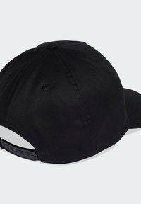 Gorra negra de tela, con visera curva, corona redondeada y una superficie texturizada. Correa de plástico ajustable en la parte posterior.