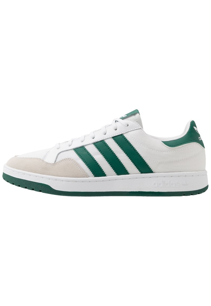 White sneaker with green accents, featuring three green stripes, textured fabric upper, suede toe cap, and a rubber sole.