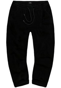Schwarze Cordhose mit elastischem Bund und Zugband, seitlichen Taschen und schmal zulaufenden Knöcheln. Glatte Textur mit geripptem Muster.