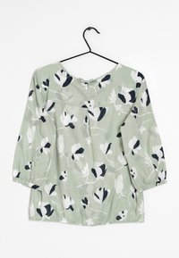 Maglietta verde chiaro a maniche lunghe con stampa floreale in bianco e nero, con scollo rotondo e dettagli con bottoni sul retro.