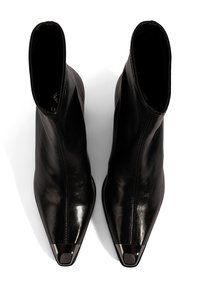 Bottes de cheville en cuir noir avec une texture lisse, bout pointu et accents en métal brillant. Présente un design élégant et sans couture.