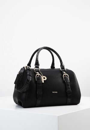 Czarna skórzana torebka z dwoma uchwytami, regulowanym paskiem na ramię, złotymi klamrami i wiszącym zawieszkiem w kształcie litery "P" na białej powierzchni.