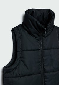 Veste sans manches matelassée noire avec col montant et fermeture éclair devant sur un fond gris clair.