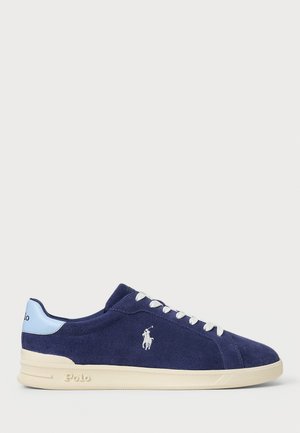 Baskets basses en daim bleu marine avec lacets blancs, semelle crème, logo Polo sur le côté et languette de talon bleu clair avec texte Polo.