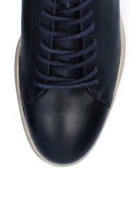 Granatowe skórzane trampki z zaokrąglonym noskiem, płaską beżową podeszwą i kontrastującymi sznurówkami. Gładka tekstura z minimalnymi detalami projektowymi.