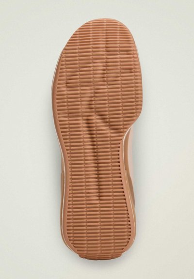 The image depicts a brown rubber shoe sole with textured ridges and grooves for grip, rounded edges, and a smooth finish.
