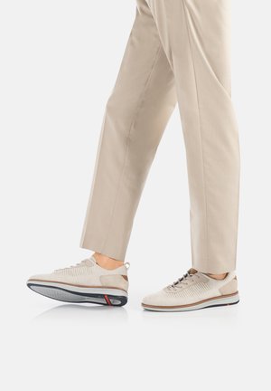 Beige Sport Schuhe mit texturiertem Obermaterial, Schnürdesign und kontrastierender Sohle. Verfügt über einen gepolsterten Schaft und eine flexible Laufsohle.