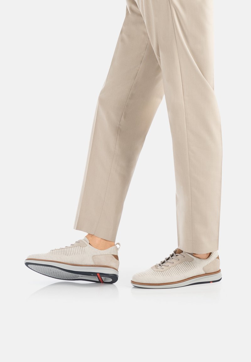 Beige Sport Schuhe mit texturiertem Obermaterial, Schnürdesign und kontrastierender Sohle. Verfügt über einen gepolsterten Schaft und eine flexible Laufsohle.