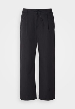 Wide-leg pants in textured black fabric with a drawstring waistband, featuring two front pockets and a straight cut design.