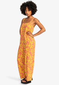 Mono sin mangas con un estampado floral en tonos rosa y amarillo, de corte holgado, fabricado en un tejido ligero, con piernas anchas y accesorios de hardware mínimos.