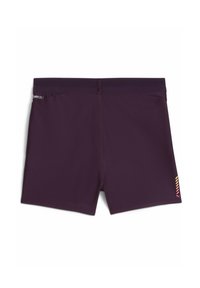 Mørk lilla shorts med en glat tekstur, tætsiddende pasform, en lille lynlåslomme bagpå og et logo med gule og røde detaljer på siden.