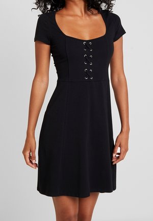 Black, short-sleeved dress with round neckline and lace-up front detail. Made of smooth fabric, flares gently from waist.