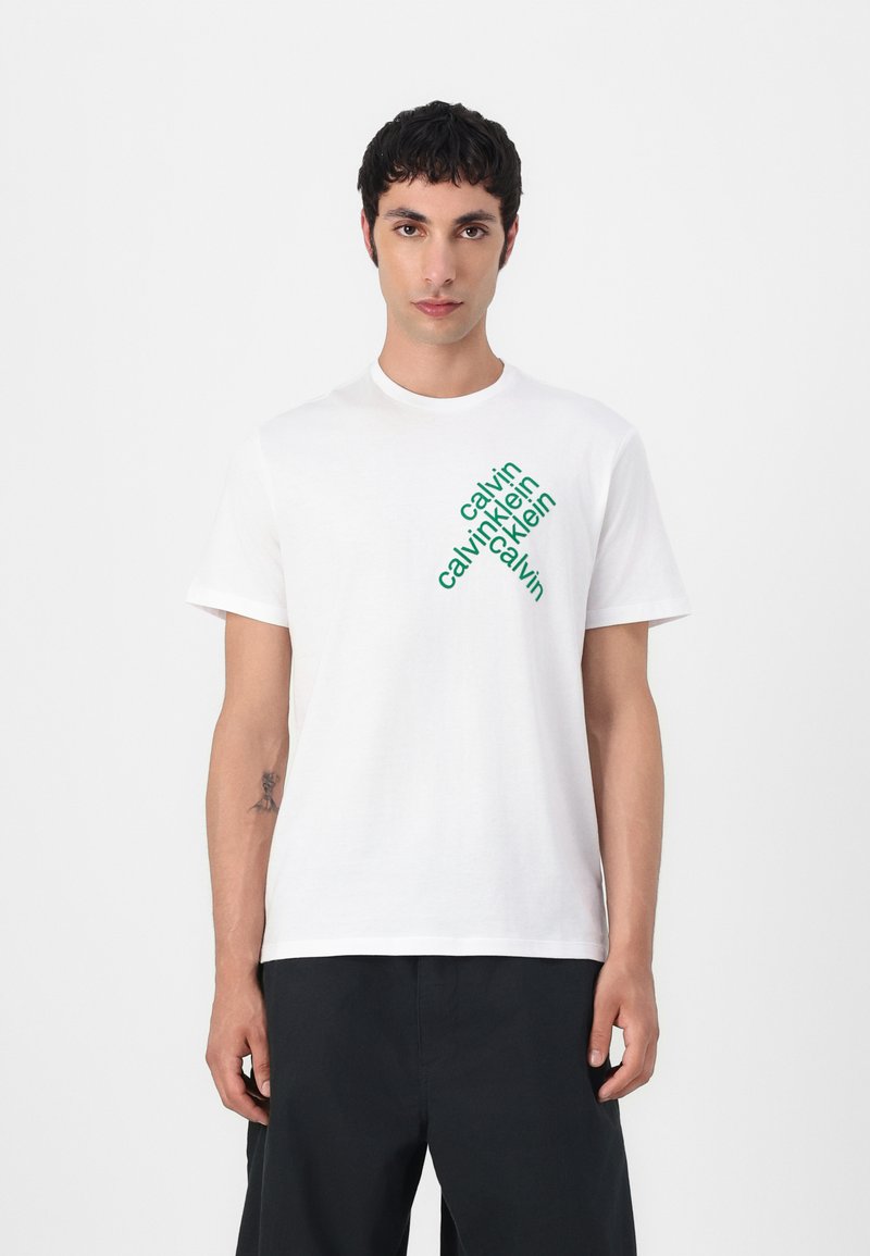 Hvid bomulds t-shirt med diagonalt grønt logo tryk. Klassisk crew neck design med korte ærmer og en afslappet pasform.