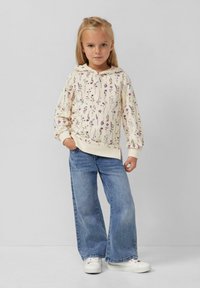 Felpa con cappuccio crema con stampa floreale lavanda, abbinata a jeans a gamba larga blu chiaro e sneakers bianche. Design semplice, texture morbida.