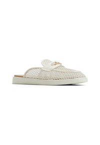 Läpinäkyvät verkkokangas slip-on -kengät kevyellä kermaharmaalla pohjalla, joissa on pehmustettu pohja ja koristeellinen kultainen varuste strapissa.