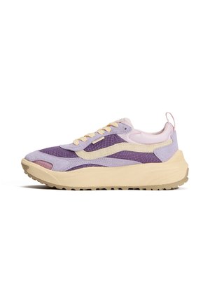 Matala lenkkari pastellinvioletissä, jossa beigen värisiä yksityiskohtia ja paksu, teksturoitu beige pohja, sivussa vetolenkkki sekä aaltoileva kuvio päällisessä.