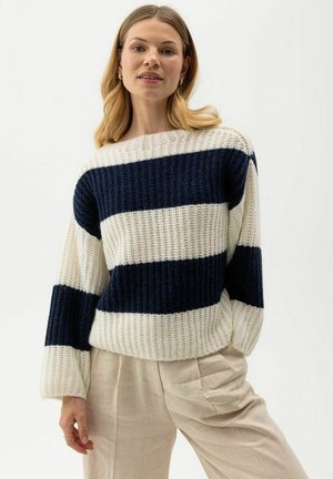 Gehaakte gestreepte trui in crème en marineblauw, met een relaxte pasvorm, brede bootnek, lange mouwen en geribbelde structuur. Combinatie met lichte broeken.