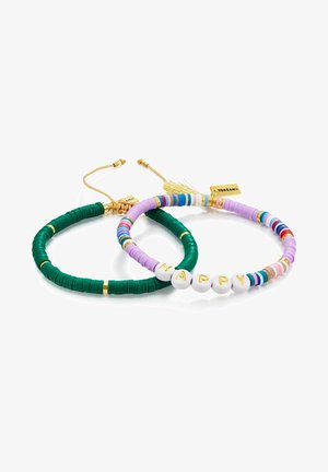 Divi rokassprādzes: viena zaļa gumija, otra purpura ar krāsainiem pērlēm. Purpura rokassprādzei ir baltas pērlītes, kas veido vārdu "LAIMĪGS". Zelta akcenti.