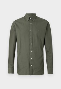 Camisa verde oliva de manga larga con botones, con cuello puntiagudo, que presenta botones blancos y un pequeño emblema bordado en el pecho.