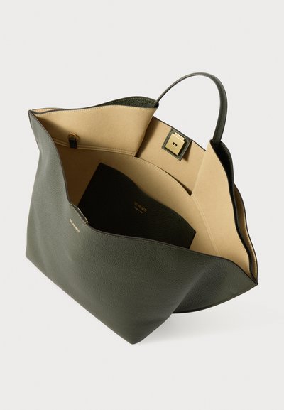 Grøn læder tote taske med en struktureret design, åben top, tan indvendig foring og en guld tryklås lukning. Bemærkelsesværdig indvendig lomme detalje.