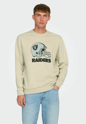 Hellbeige Sweatshirt mit runder Ausschnittkante und gerippten Bündchen. Mit einem Grafikdesign eines Raiders-Helms und dem auffälligen Schriftzug "RAIDERS" in Schwarz.
