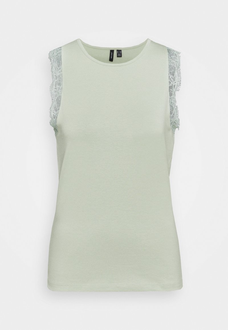 Top verde chiaro senza maniche con scollo rotondo, caratterizzato da pizzi sulle spalle. Materiale in cotone morbido con una texture liscia.
