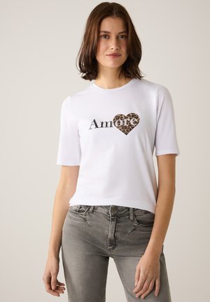 White short-sleeve t-shirt featuring a leopard print heart with the word "Amore" in black lettering across the chest. Soft cotton fabric.
