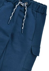 Navy blue jogger pants made of soft fabric, featuring an elastic waistband, drawstring with metal accents, and side pockets.