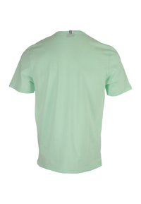 T-shirt verde menta a maniche corte, con collo rotondo, realizzata in morbido cotone. Presenta un piccolo cartellino a righe sul collo per un tocco in più.