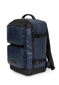Zaino di colore blu navy con dettagli neri, realizzato in materiale resistente. Presenta numerose tasche con cerniera, spallacci imbottiti e una maniglia superiore.