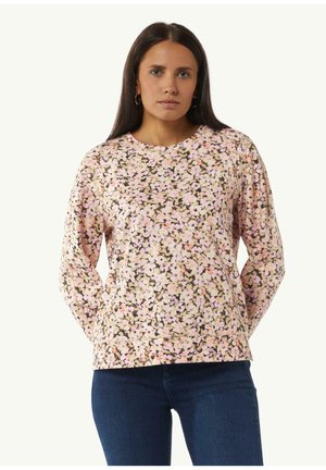 Lange mouwtop met bloempatronen in pastelroze, met een ronde halslijn en zachte, gestructureerde stof. Gecombineerd met blauwe spijkerbroek.
