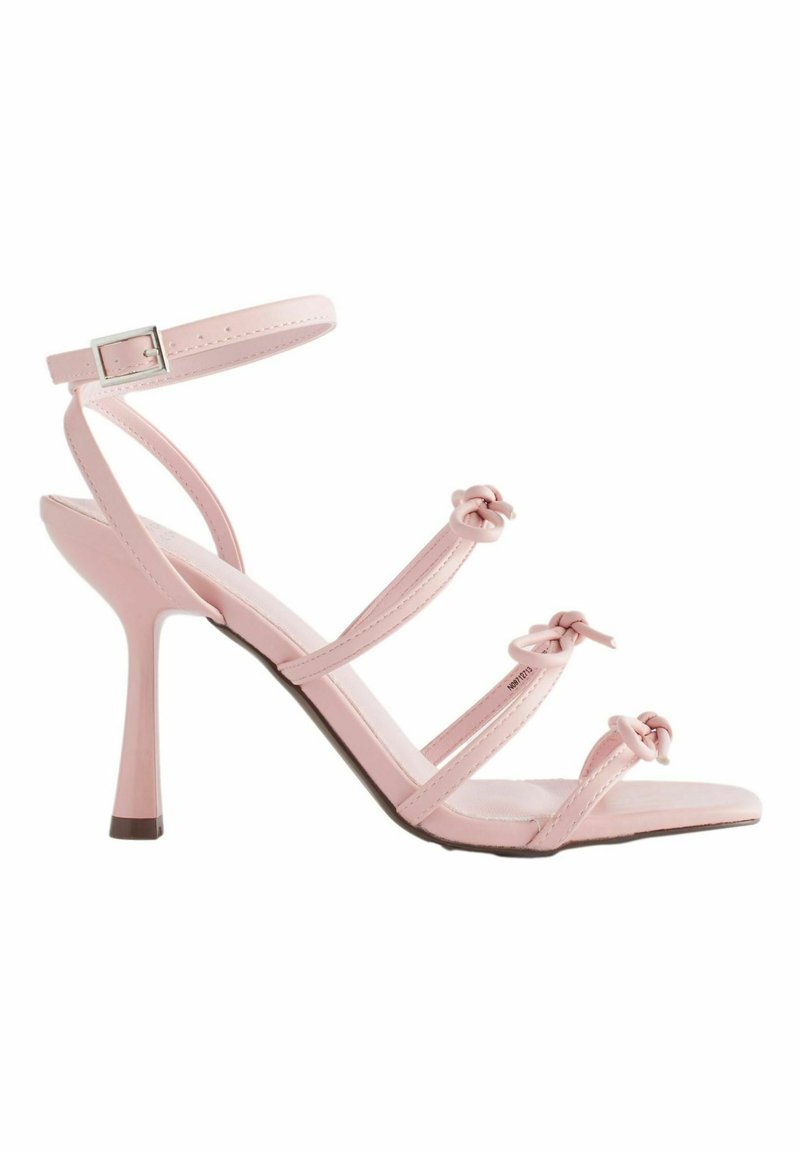 Rosa High Heel Sandalen mit einem Riemendesign, das drei geknotete Akzente, einen Knöchelriemen und eine glänzende Oberfläche aufweist. Stiletto-Absatz.