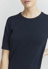 Navy blue short-sleeve knit top with a crew neckline and smooth texture. Features a fitted silhouette and minimal stitching details.