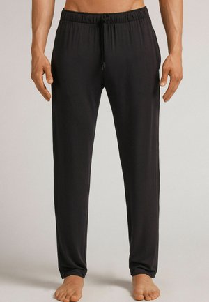 Schwarze, leichte Hose mit elastischem Bund und Kordelzug. Weiche Textur und lockere Passform, die zum Knöchel hin schmaler wird. Keine Taschen.