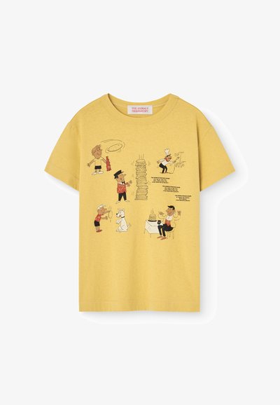 Camiseta de algodón amarilla con personajes de dibujos animados impresos, incluyendo un chef y un perro, con elementos de comida y texto divertido.