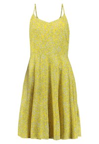 Gul blommig klänning med tunna axelband, åtsittande liv och utställd kjol. Har ett mönster av vita blommor på en livlig gul bakgrund.