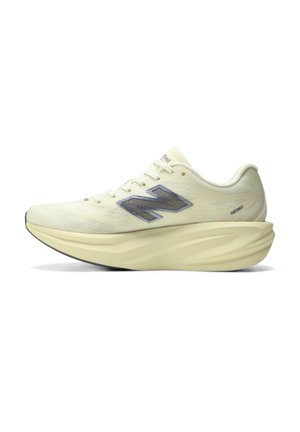 Hellbeiger New Balance Laufschuh mit dicker, geformter Sohle, grauem Seitenlogo und Schnürsenkeln, von der Außenseite gesehen.