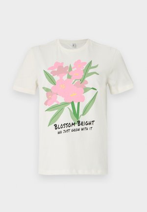 T-shirt de algodão creme com mangas curtas, apresentando uma ilustração de uma flor rosa. O texto abaixo diz "Floreça Brilhante e Apenas Cresça com Isso."