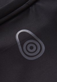 Sort tekstureret stof med et metallisk avocado-logo og koncentriske cirkeldetaljer i midten. Glat finish, subtil glans mod en mat baggrund.